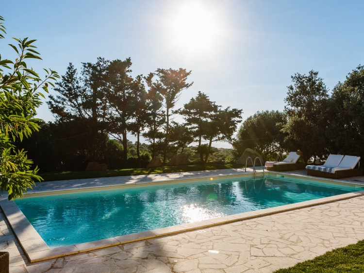 Sunny view of the pool and sunloungers at Borgo Lu Puleu